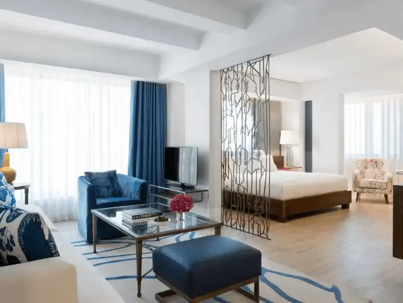 A cozy yet stylish suite at The Merchant House, designed with contemporary décor and rich blue accents.