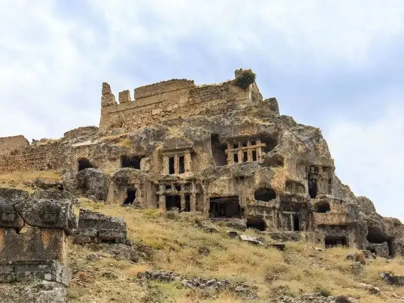 A captivating view of the ancient ruins of Tlos, with its stone structures nestled amidst the hills, highlighting the historical significance of this ancient Lycian city.