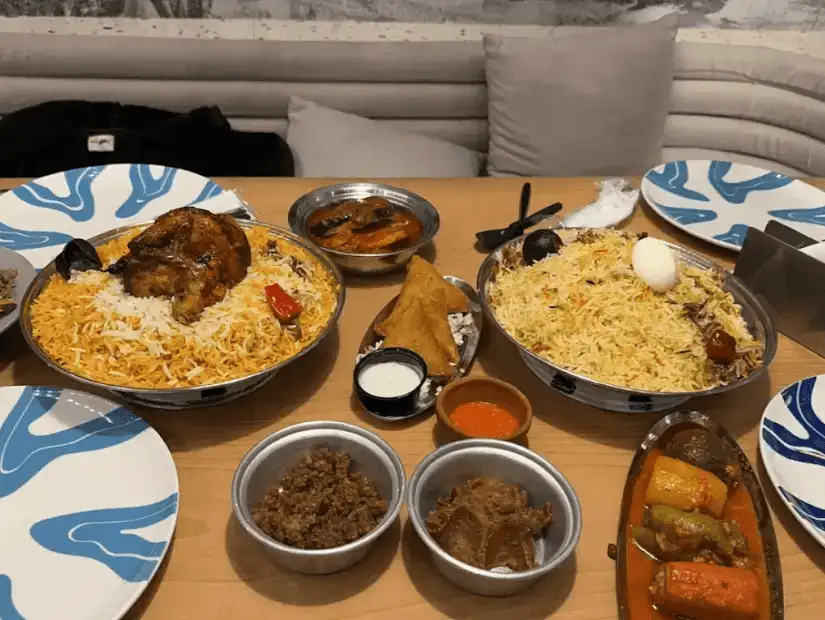 A beautifully presented platter with flavorful biryani rice, grilled chicken, and accompanying sides.