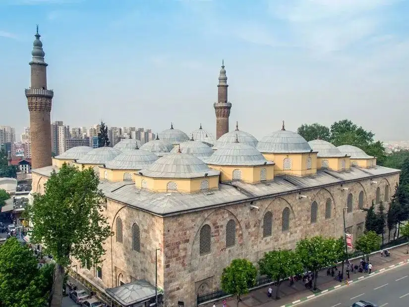 The majestic Grand Mosque in Bursa, featuring its iconic domes and minarets against the modern city backdrop.