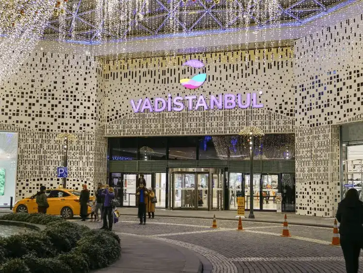 Twinkling lights adorn the entrance of an elegant shopping complex during evening hours.