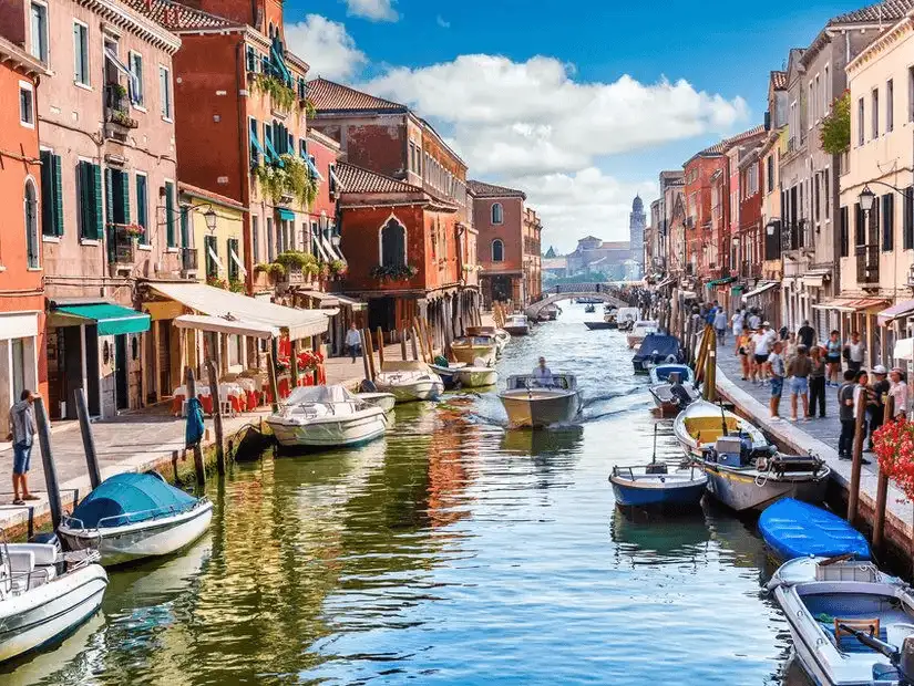 The lively and busy canals of Venice, with gondolas and boats navigating through the city's waterways.