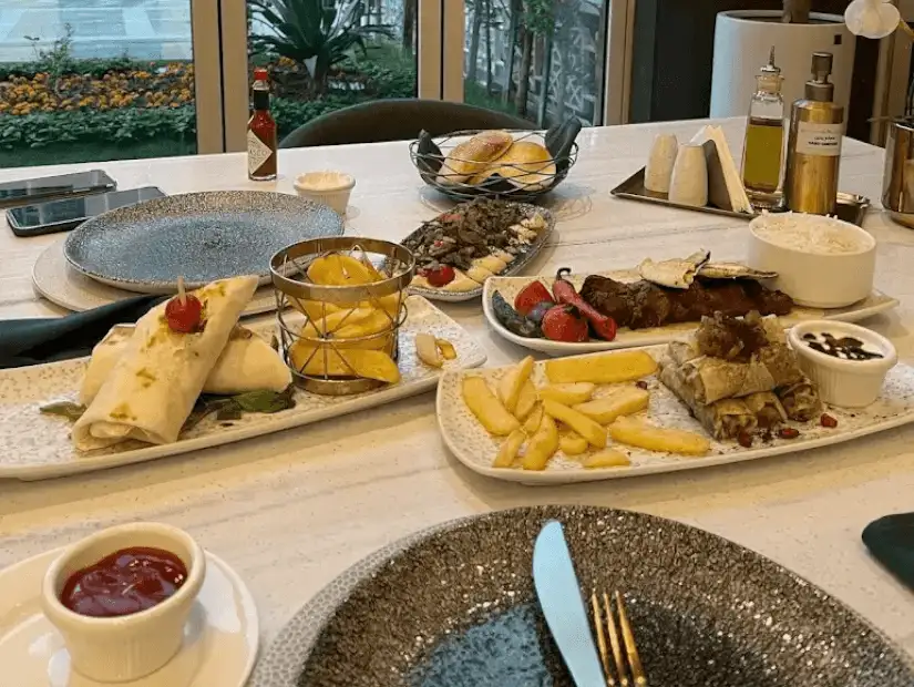 A delicious spread with grilled kebabs, rice, sauces, and fresh sides like tomatoes and greens.