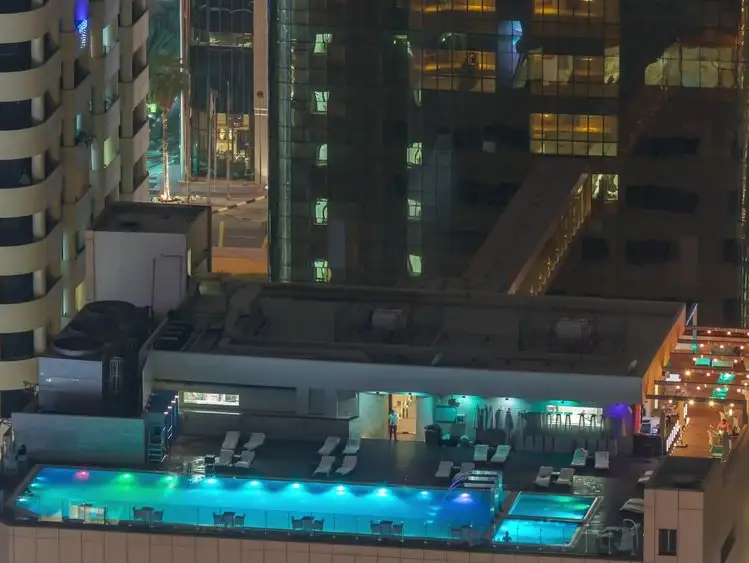 The iconic Paramount Hotel Dubai, a towering structure with sleek, modern design under clear skies.