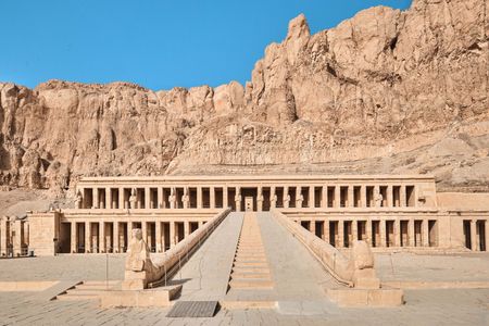 في قلب الصحراء الغربية، عند سفوح جبل الدير البحري القاحلة، يقف صرحٌ معماري يخطف الأبصار ويأسر الألباب، يروي قصة امرأة سبقت زمانها، وتحدت الأعراف لِتتربع على عرش أعظم حضارة عرفها التاريخ